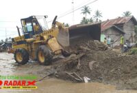 Photo, Alat Berat Bulldozer Membersihkan Material Yang Menutupi Jalan Lintas Nasional.